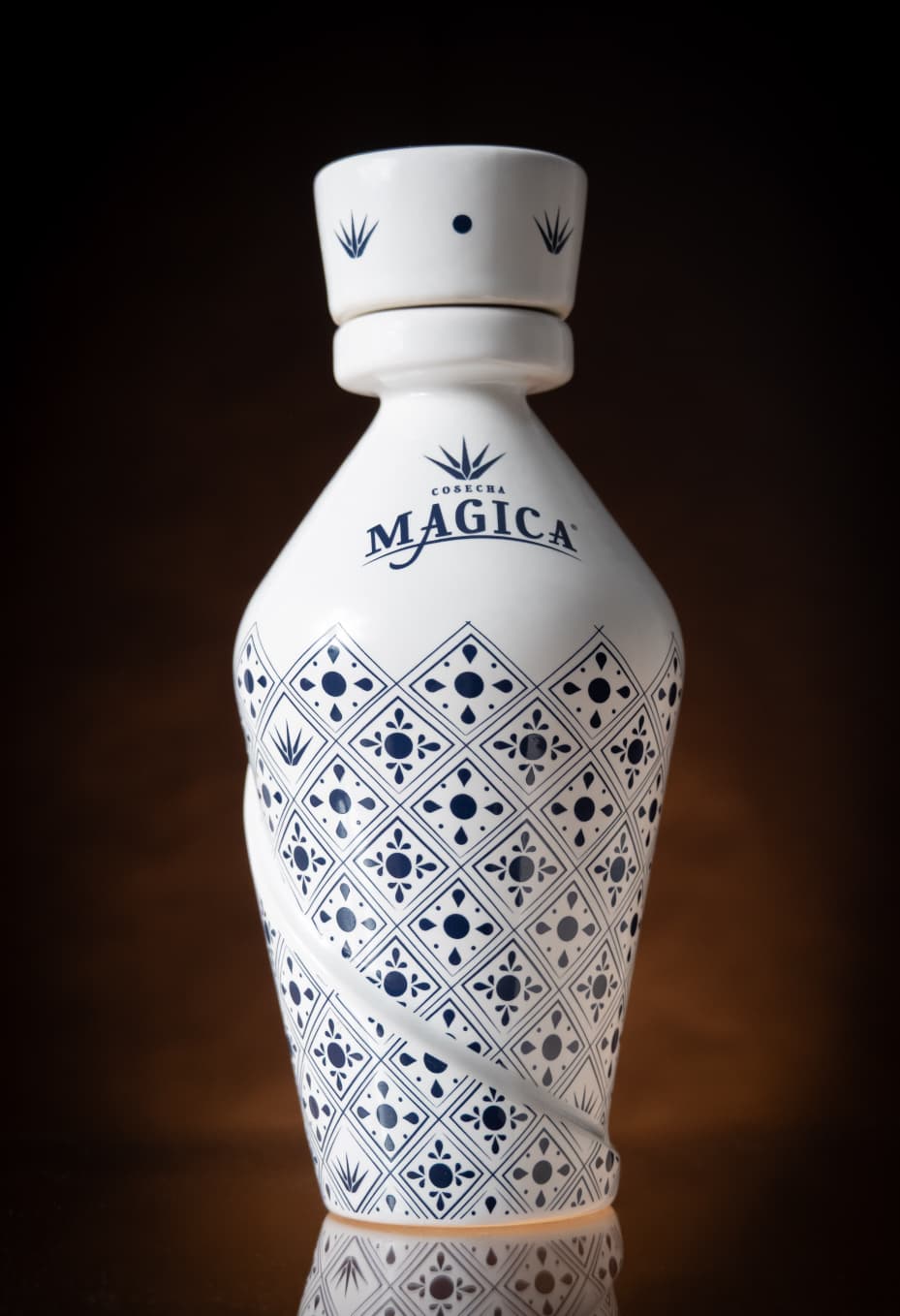 White patterned ceramic bottle against a dark brown background