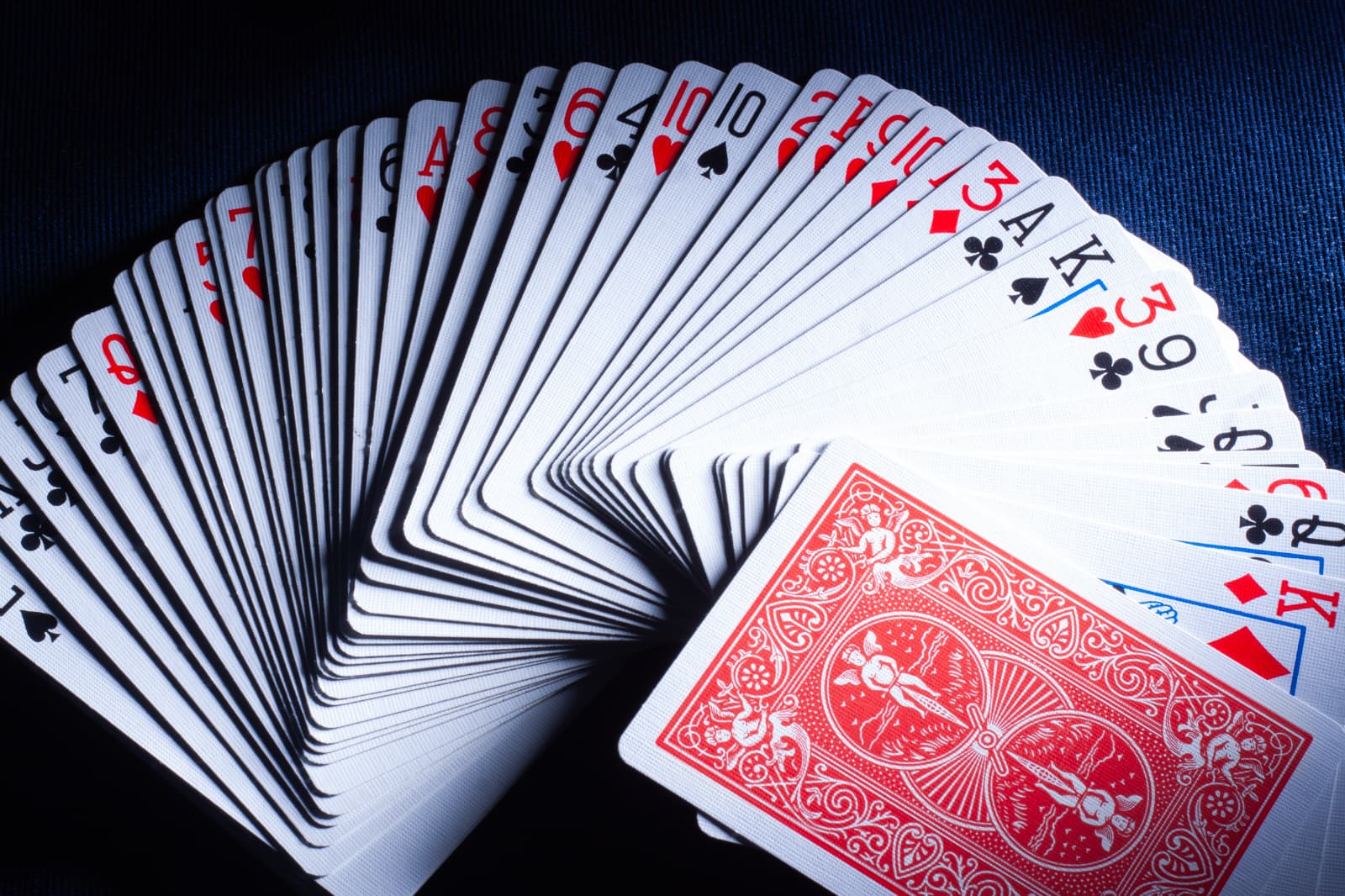 Playing cards fanned over dark cloth