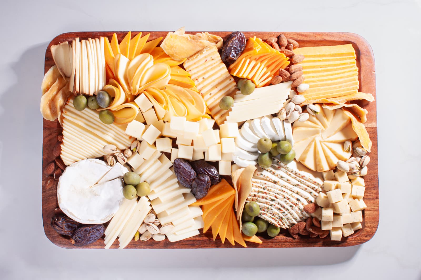 Assorted cheeses, grapes, nuts and dried fruit on a board