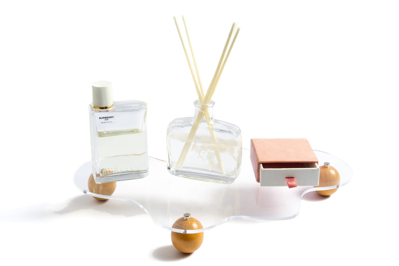 Fragrance bottle, diffuser and small box arranged on a display stand